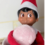 Image of Elf on a Shelf in coffee mug holding strawberry My/Mochi ball